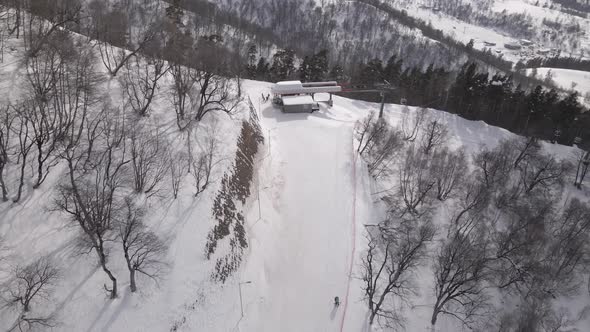 Flying over rope-way with gondolas at mountain resort Crystal Park in Bakuriani. Snowy winter day.
