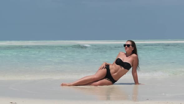 Young Woman in Bikini Tans on an Empty Paradise Beach on Island in Ocean Mnemba