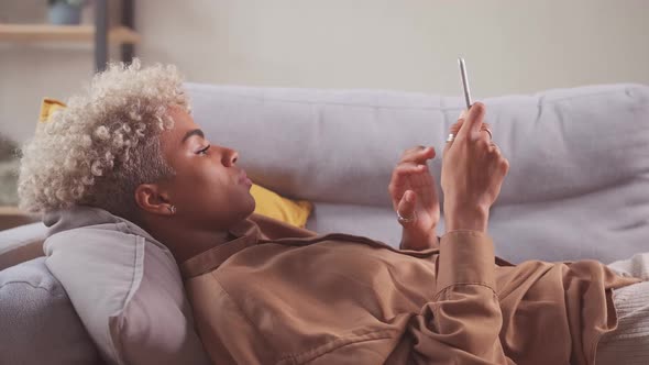 African Young Lady Spend Leisure Time Alone Surfing Internet on Pad Pc Device