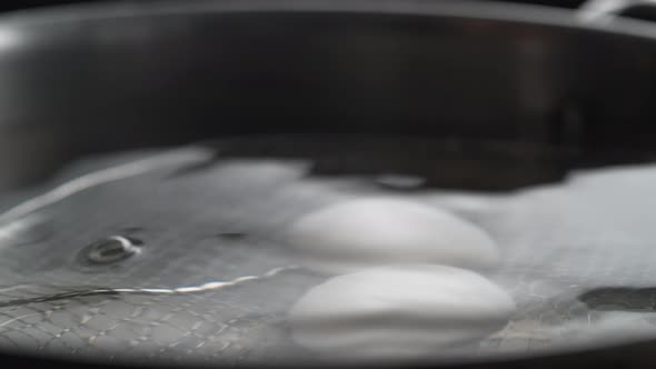 Taking boiled eggs out of boiled water. Slow Motion.