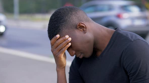 depression due to the covid - desperate black man holds his head with his hands