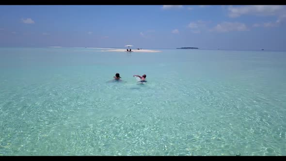 Man and woman suntan on idyllic resort beach break by blue sea and white sand background of the Mald