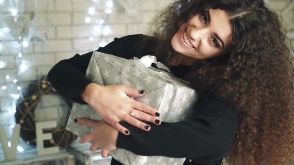 Woman opening gift boxes. Young woman with presents in New Year interior in the living room