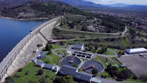 High aerial view over the Navacerrada Reservoir and dam as well as the Sewage treatment plant.