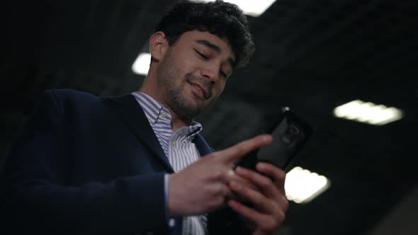 Happy Man with Smartphone Moving Down on Escalator