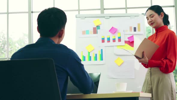 Young Woman Explains Business Data on White Board