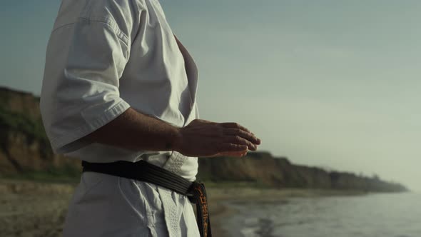 Karate Master Honing Fighting Exercises on Seashore Close Up