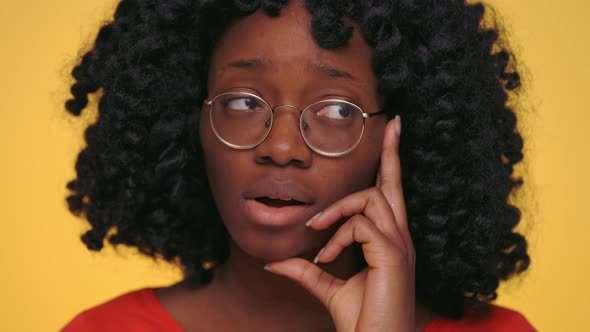 African Woman Standing in Doubt Over Yellow Background