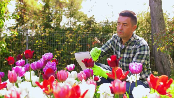 Man with Notebook and Flowers at Summer Garden