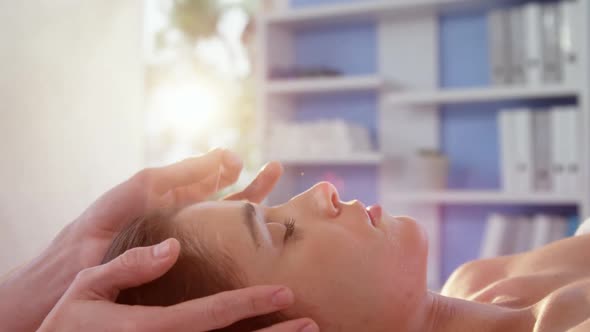 Female patient receiving head massage from physiotherapist