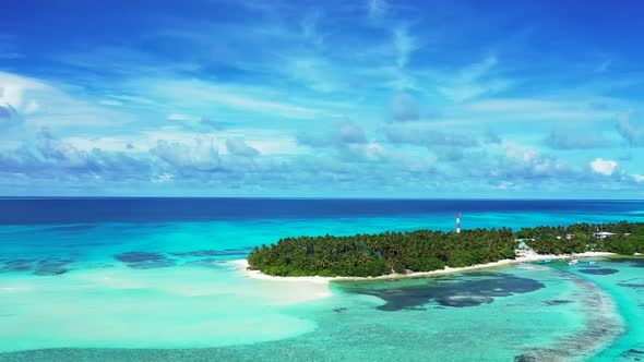 Aerial view sky of idyllic tourist beach vacation by shallow sea with bright sandy background of a d