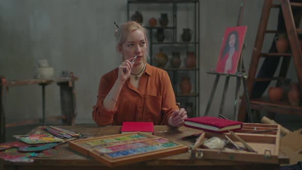Thoughtful Female Artist Pondering Over Design of Painting