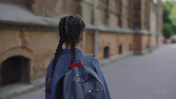 Back View of Little Girl Walking Around the Street Near School in Jeans Jacket