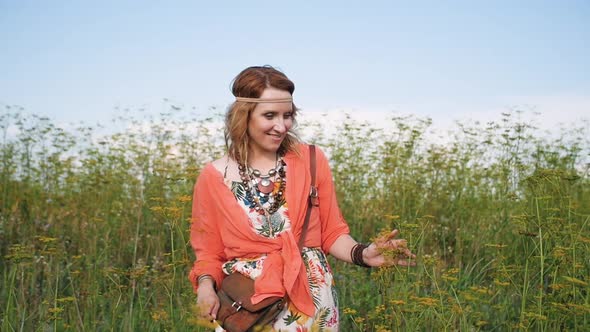 Portrait of Blonde Hippie Dancing in a Field with Flowers