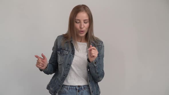 Beautiful caucasian girl dancing in front of the camera and listening music with closed eyes.