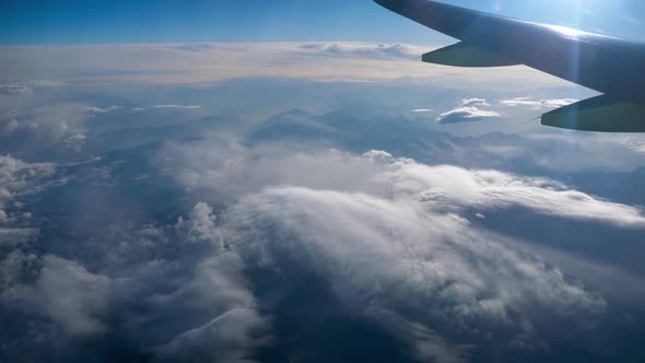 Beautiful View Through Airplane Window, Airplane Flying Above City in Mountains