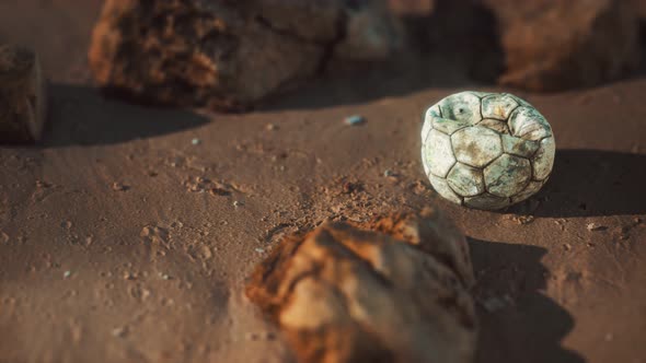 Old Football Ball on the Sand Beach