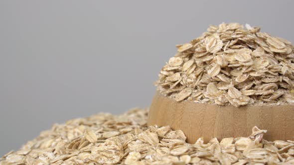 Organic products. Oatmeal on white background. Oat flakes in wooden bowl.