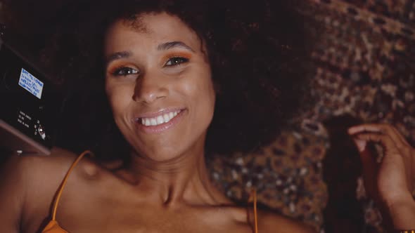 Woman With Afro Hair Smiling With Vintage 8Mm Camera