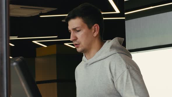 Close Up of Young Man Running on Treadmill in a Gym