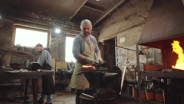 Senior Blacksmith Working with Wrought Iron Rod