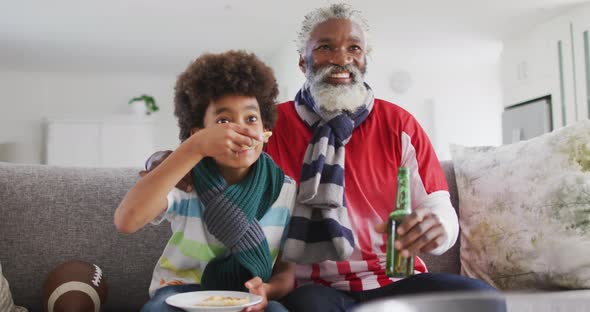 African american senior man and grandson at home sitting on a sofa in the living room