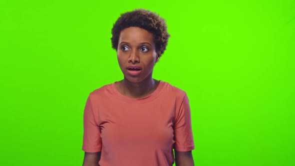 Young African American Woman Sneezes Covering Mouth with Hands and Smiling