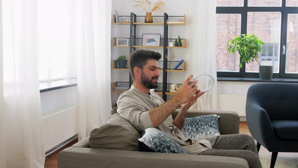 Man in Headphones Listening To Music on Smartphone