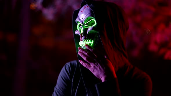 Suit for Halloween Mask with Glowing Skull Green Lights in Darkness on Street in Night