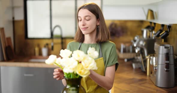 Woman Decorates Home Interior with a Bouquet of Fresh Flowers