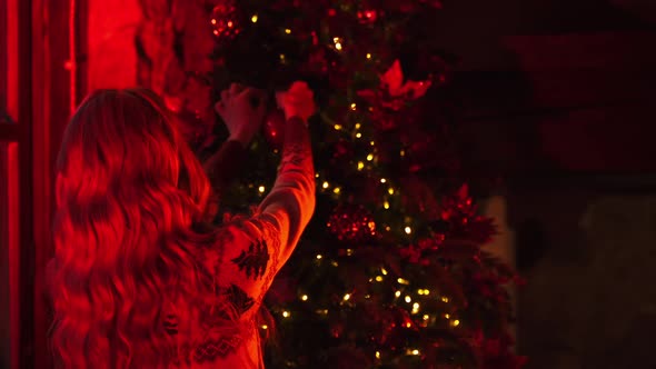 Woman decorates New year tree.