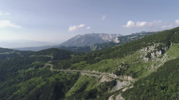 Aerial Drone Shot. Alpine Road and Rocky Mountain Ridge on the Background. Durmitor National Park