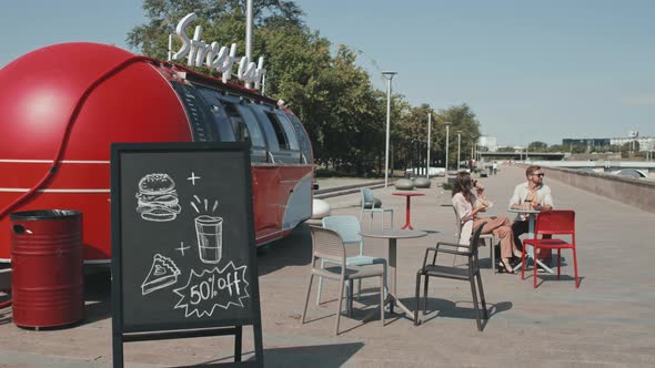 Couple Eating Street Food Outdoors in Summer