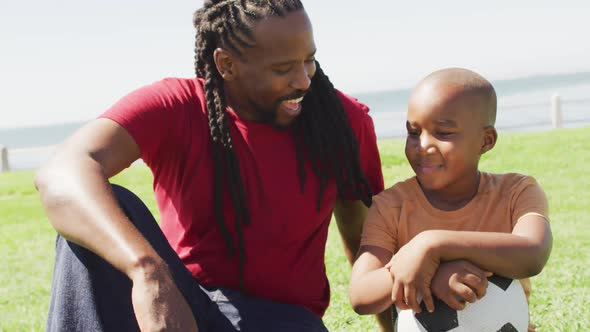 Video of happy african american father and son having fun outdoors