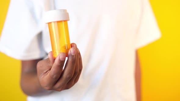 Young Man Hand Holding Medicine Pill Container