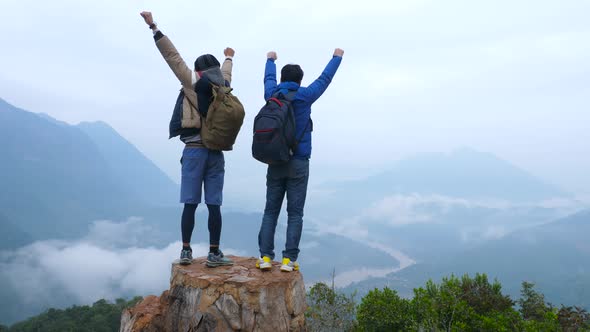 Two Hikers Celebrating on Top of a Mountain