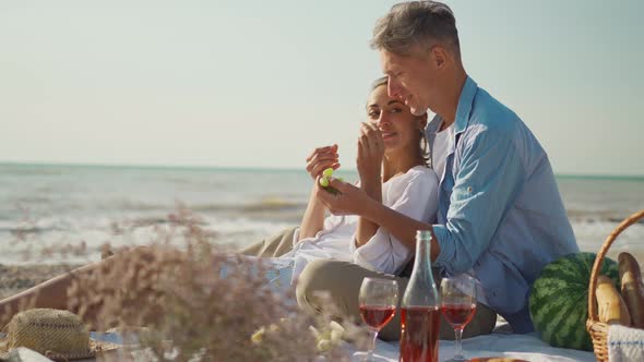 Beautiful Lovely Couple Having Romantic Date at Sea Beach Feeding Each Other By Fruits