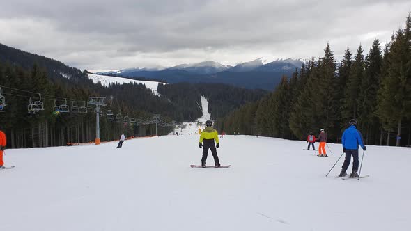 People skiing on the snowy slope of Bukovel ski resort in the Ukrainian Carpathian mountains.