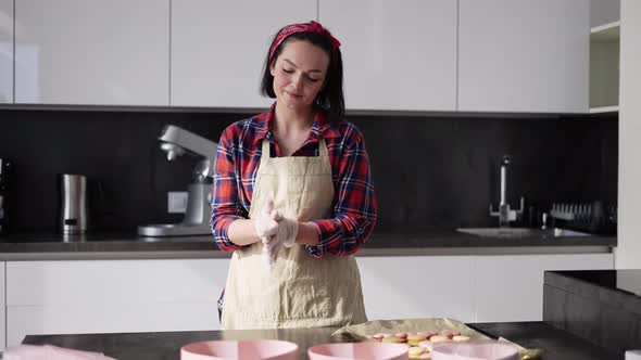 Woman Putting on Culinary Gloves on Kitchen