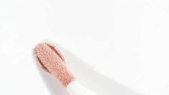 Macro Shot and Slow Motion of a Brush Applicator Smear Concealer Isolated on White Background