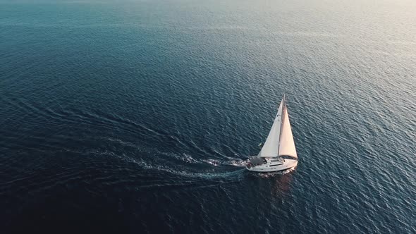 Aerial View on White Sailing Yacht with Flag of Ukraine on It. Floating Across Mediterranean Sea