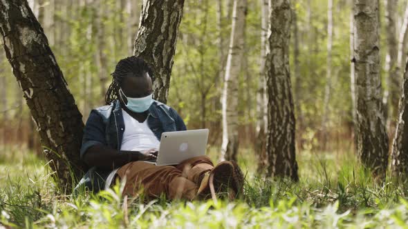 New Normal. Remote Work Concept. African Man Using Laptop in the Nature