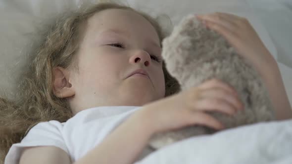 Little Curly Kid Lying in Bed