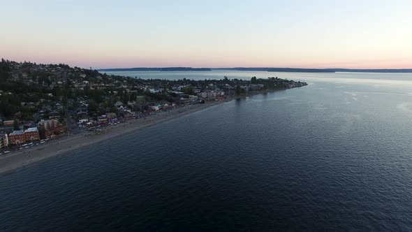 Wide establishing aerial shot of the Alki Beach shoreline in West Seattle.