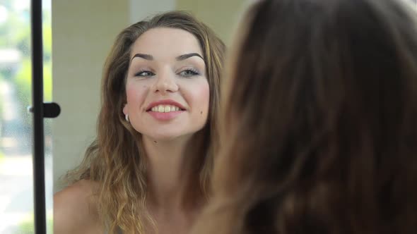 Beautiful Woman Looking to the Mirror and Admire Herself