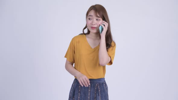 Happy Young Beautiful Asian Woman Talking on the Phone