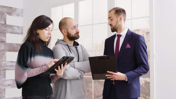 Real Estate Agent Talking with Couple and Holding Documents