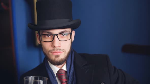 Handsome Young Man in a Classic Suit Drinking Whiskey