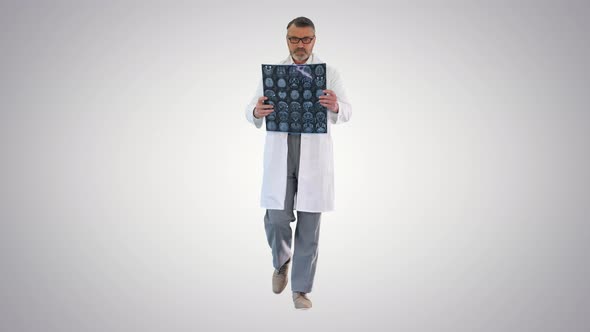 Mature Physician Walking and Reviewing a MRI Brain Scan on Gradient Background.