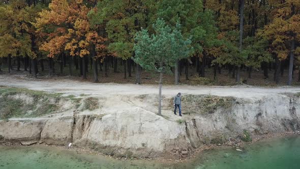 Photographer working on shore. Aerial view of photographer taking photo of nature on lake shore